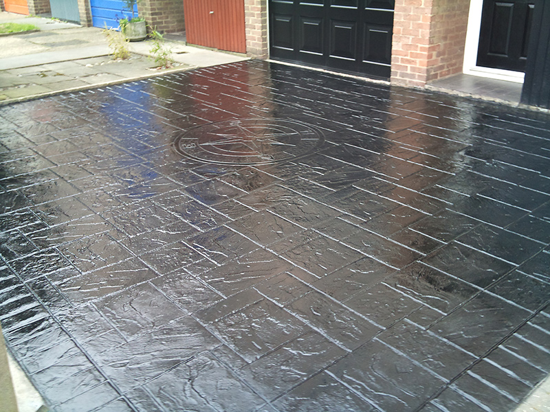 black driveway finished with imprinted concrete