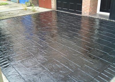 black driveway finished with imprinted concrete